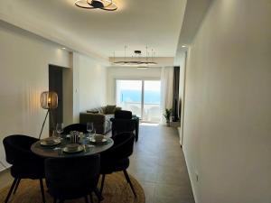 a living room with a table and chairs and a couch at Joyscape beachfront residence in Larnaca