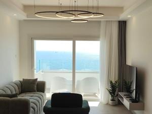 a living room with a couch and a large window at Joyscape beachfront residence in Larnaca