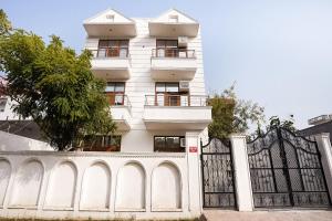 un edificio blanco con una puerta y una valla en Hotel O Royal Inn, en Faridabad