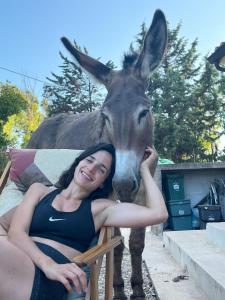 a woman is posing in front of a donkey at Villa del Lupo in Santa Maria la Palma