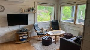 a living room with a tv and a couch and a table at Kallio-Orava Villa with jacuzzi in Koljonkanta