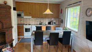a kitchen with a table and chairs and a clock at Kallio-Orava Villa with jacuzzi in Koljonkanta