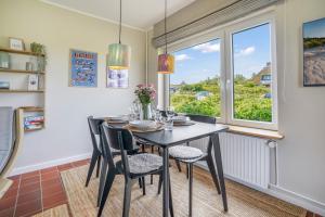 ヘルヌムにあるHaus Hildebrandのテーブルと椅子と窓のあるダイニングルーム