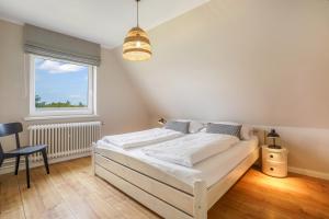 ヘルヌムにあるHaus Hildebrandの白いベッドと窓のある寝室