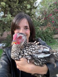 a woman holding a chicken in her hands at Villa del Lupo in Santa Maria la Palma