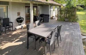 a wooden table and chairs on a deck at Holiday Home Jacobslystvej Gilleleje Xi in Gilleleje +9 photos