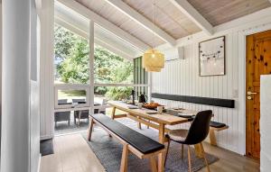 a dining room with a table and chairs and a window at Holiday Home Gyldenrisvej Denm in Skattebølle +19 photos