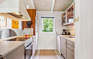 a kitchen with white cabinets and a window at Holiday Home Gyldenrisvej Denm in Skattebølle