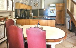 a kitchen with a table and chairs and a kitchen with a counter at Authentique Maison Campagne in Montredon-Labessonnié