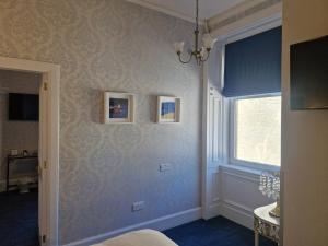a room with a blue wall with a window and a windowpect at Corriemar House in Oban