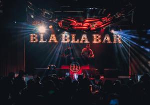 a man on a stage in front of a neon sign at Oasis апартаменты на левом берегу, новый ремонт in Astana +65 photos