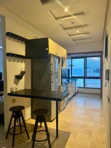 a kitchen with a black table and two stools at Appartement familial in Casablanca