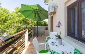a patio with a table and an umbrella on a balcony at Stunning Apartment In Valbandon in Valbandon