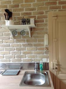 - un évier dans la cuisine dotée d'un mur en briques dans l'établissement Le Petit Beurre, à Beaune