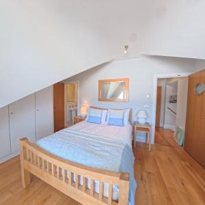 a bedroom with a large bed with blue pillows at Tate Five Penthouse apartment with panoramic views of St Ives in St Ives