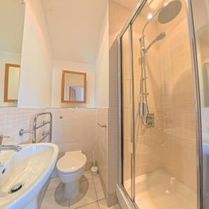 a bathroom with a shower and a toilet and a sink at Tate Five Penthouse apartment with panoramic views of St Ives in St Ives
