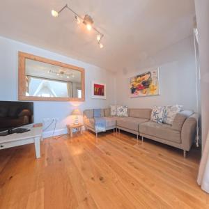 a living room with a couch and a table at Tate Five Penthouse apartment with panoramic views of St Ives in St Ives