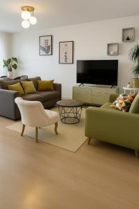 a living room with two couches and a flat screen tv at Agréable 3 pièces - 8P - Parking - Séjour idéal Paris Proche Gare in La Courneuve