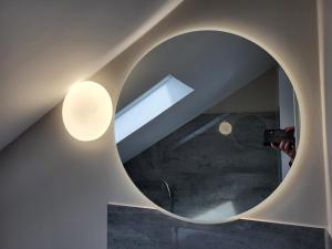 eine Person, die ein Bild eines Gebäudes mit einem Spiegel macht in der Unterkunft Fredi Apartment, moderne ruhige Wohnung, nur 4 km von der A2 in Leopoldshöhe