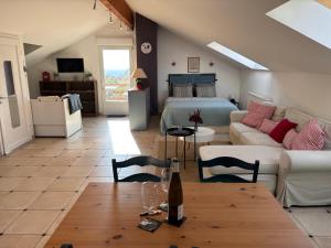 a living room with a bed and a table at Vines & views - with airconditioning in Voegtlinshoffen