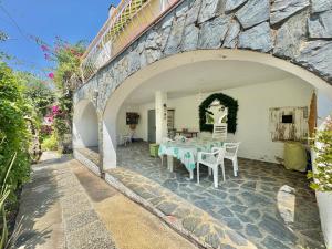 a patio with a table and chairs in a stone wall at Casita Bouganvilla in Roses
