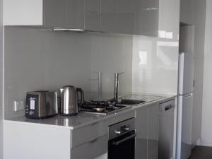 een keuken met een fornuis, een wastafel en een koelkast bij Holiday Business Trip Family Trip or Business Trip Comfortable Entire Apartment in Springvale +4 foto's