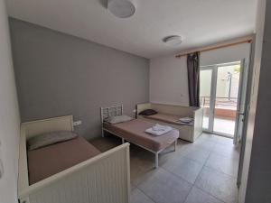 a small room with two beds and a balcony at SUBTUB Hostel Makarska in Makarska