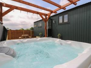 una vasca idromassaggio in un cortile con un edificio ecologico di Luxury Shepherd Hut with Private Hot Tub a Swaffham Bulbeck