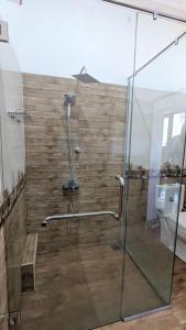 米瑞莎Nirmali Resort的带玻璃门淋浴间的浴室