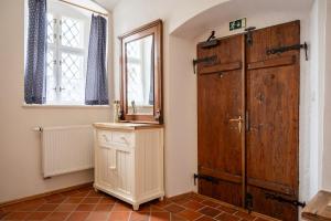a room with a large wooden door and a mirror at Penzion Renesance in Chřibská