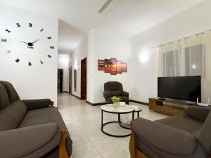 モン・ショワジーにあるVILLA DES ILES 4 à proximité de la plageのリビングルーム(ソファ、壁掛け時計付)