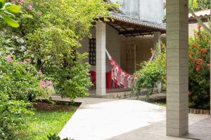 a house with a red door and a flag on it at Hotel Pousada Ipitanga IV in Lauro de Freitas