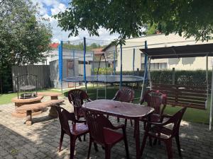 a patio with a table and chairs and a playground at Dió Apartman in Hajdúszoboszló