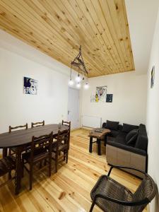 a living room with a table and a couch at Mamukas Guesthouse in Mestia +28 photos