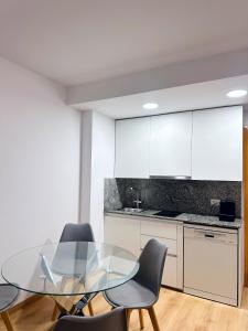 a dining room with a glass table and chairs at Sa Boadella - Fenals Beach in Lloret de Mar