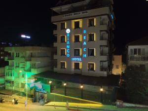a hotel building with a hotel sign at night at Bianco Beach Hotel in Kuşadası