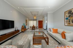 a living room with a couch and a flat screen tv at Paris Royal Estate in Lusaka