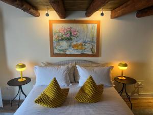a bedroom with a bed with pillows and a painting at W la stanza in Granigo
