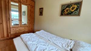 une chambre avec un lit, un miroir et une fenêtre dans l'établissement RENATE Haus KMB Seeappartement am Ossiacher See, Hallenbad, Skiarena Gerlitzen, à Bodensdorf 23 autres photos