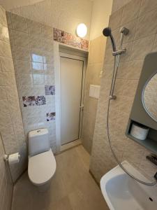 a bathroom with a toilet and a sink and a shower at NDK NEST 2BR Apartment in the Heart of Sofia in Sofia +17 photos
