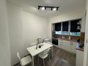 a kitchen with a white table and white chairs at NDK NEST 2BR Apartment in the Heart of Sofia in Sofia