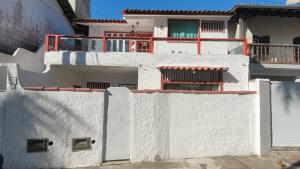 a white building with a white fence in front of it at ossos beach in Búzios