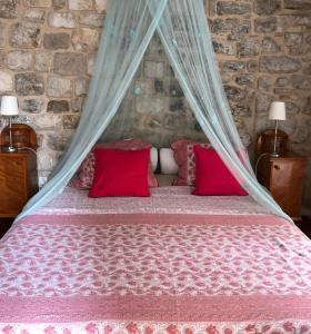 a bedroom with a bed with red pillows at Bed & Breakfast The Konoba in Šibenik