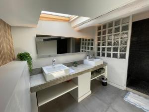 une salle de bain avec deux lavabos et un grand miroir dans l'établissement La Tuilerie du Bazalac, à La Celle-sous-Gouzon 5 autres photos