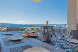 un tavolo con una bottiglia di vino e bicchieri da vino di Aliara Panorama a Vodice