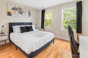 a bedroom with a bed and two windows at Stylish & Cozy 1-BR Detroit in Detroit
