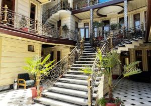 een trap in een gebouw met potplanten bij Hotel Grand House Real Estate in Bukhara