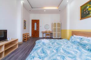 een slaapkamer met een groot bed en een televisie bij JapanRoom-1km 2 Bui Vien in Ho Chi Minh-stad