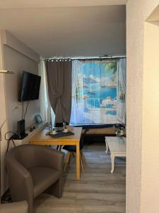 a living room with a table and a window at Comfortable studio in Bevaix with mountain view - 30 m² + Spa in Bevaix