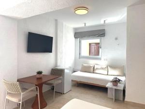 帕特莫斯Golden Sun Hotel Patmos的一间有一张床和一张桌子的小房间